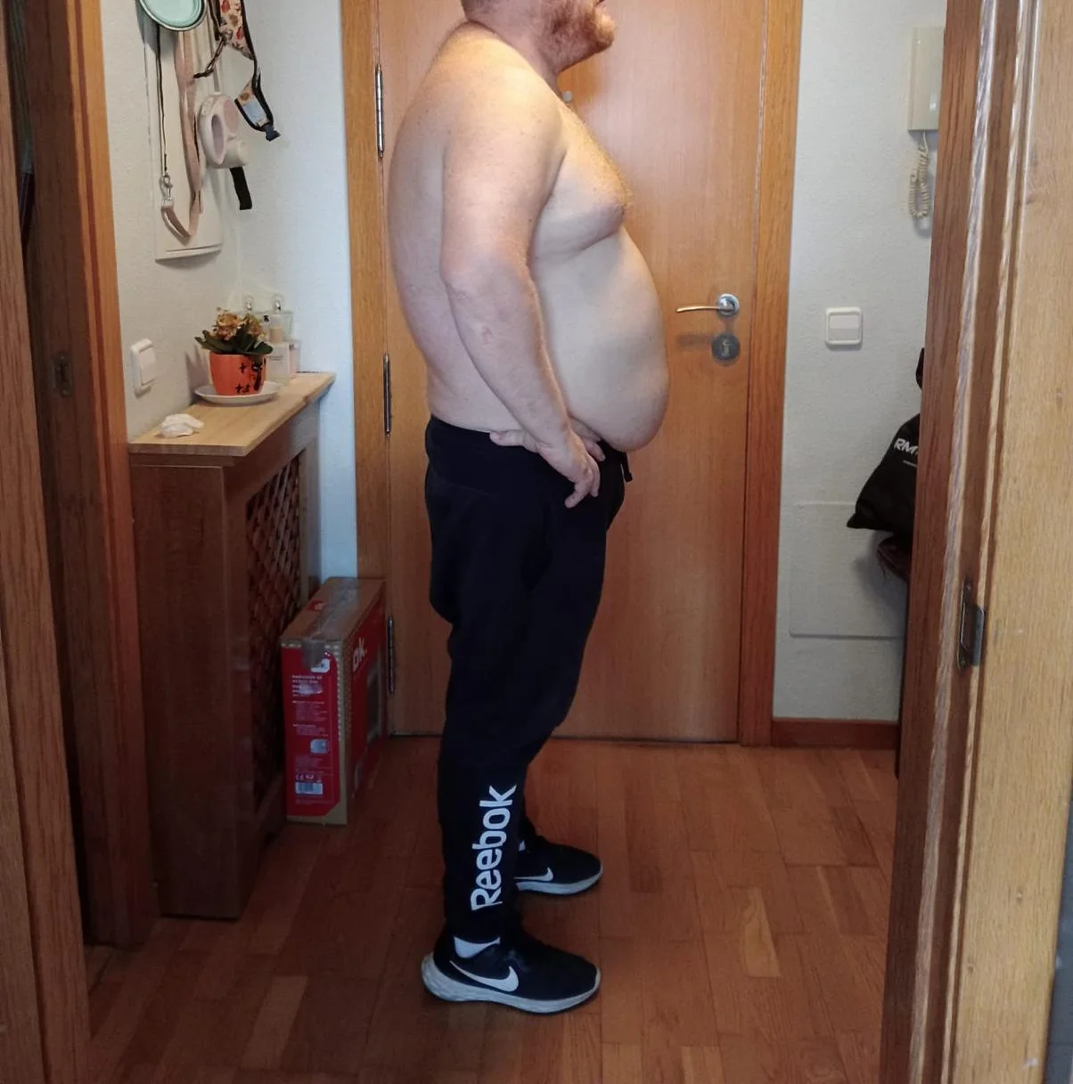 Foto del antes de una transformación de pérdida de peso; persona adulta de perfil en interior.