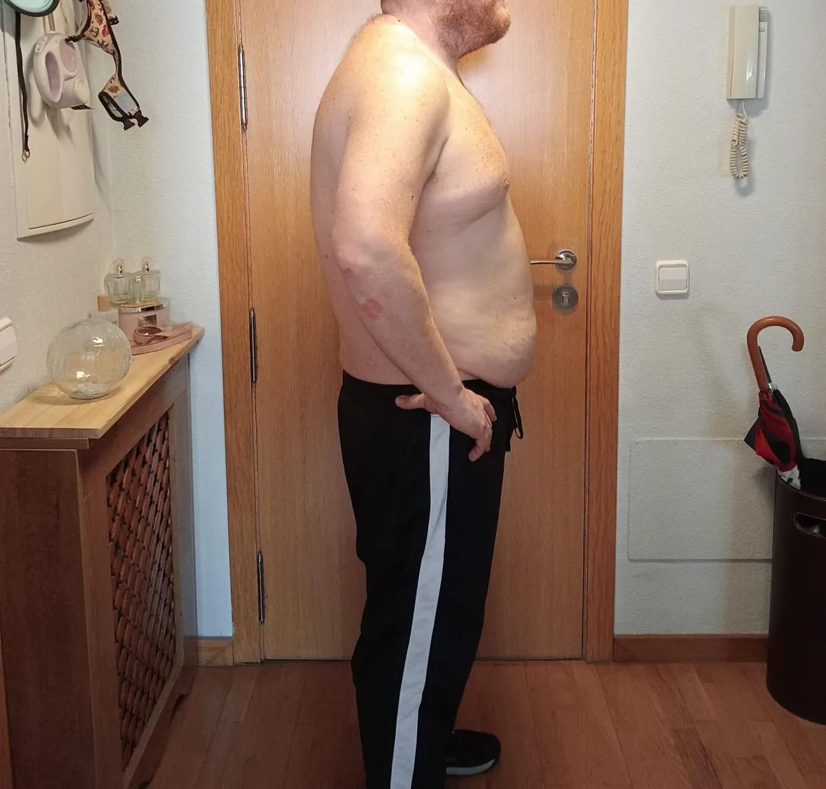 Foto del después de una transformación de pérdida de peso; persona adulta de perfil en interior.