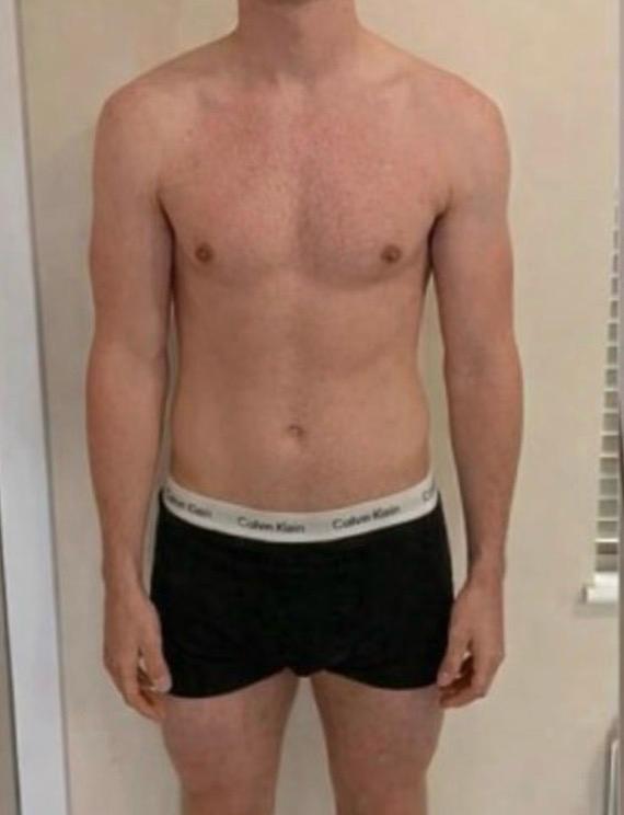 Antes de la transformación física: hombre adulto de frente en interior, con ropa interior negra.